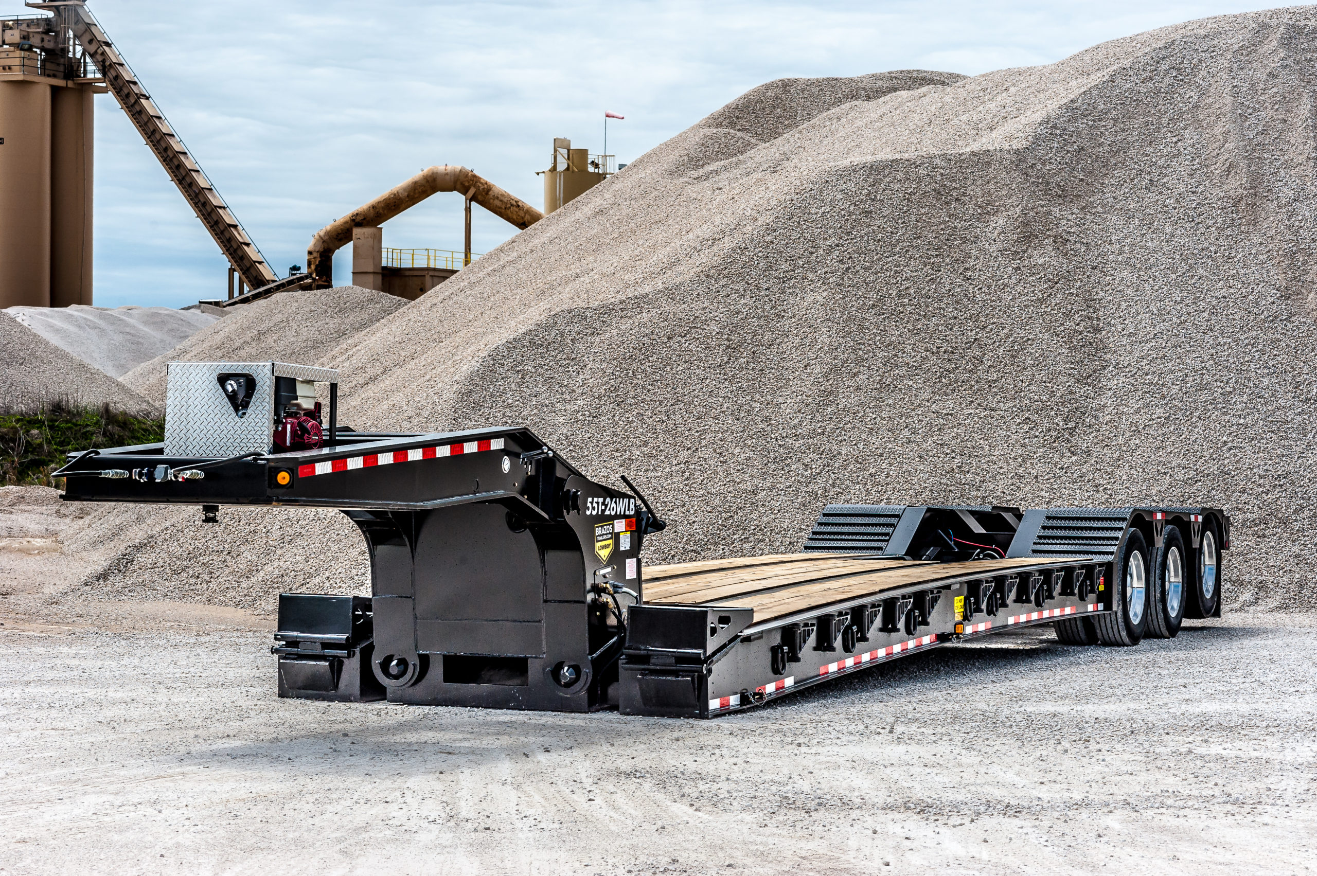 Lowboy trailer hauling heavy equipment